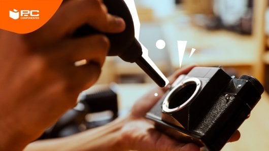 Una persona limpiando una macha de polvo del sensor de una cámra reflex