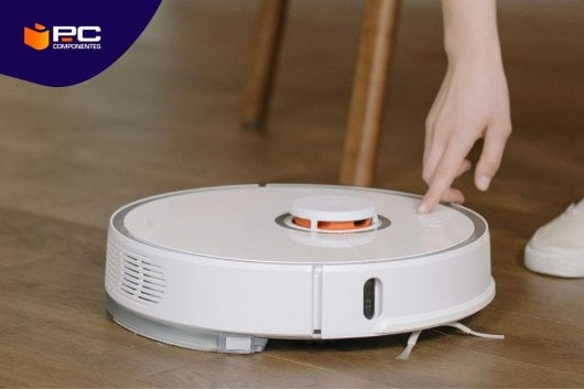 Una persona preparandose para limpiar un robot aspirador