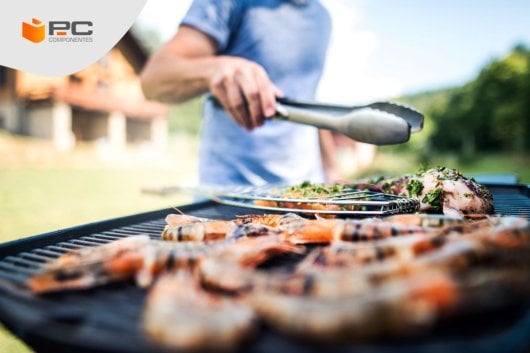 Una persona cocinando en uno de los tipos de barbacoa que existen