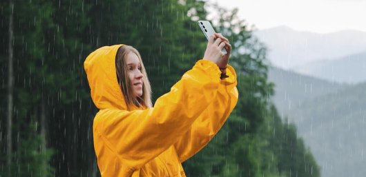 Una chica sosteniendo uno de los mejores móviles resistentes al agua de 2025