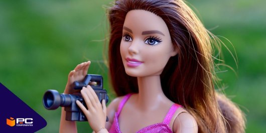 Una muñeca Barbie sostiene una cámara de vídeo