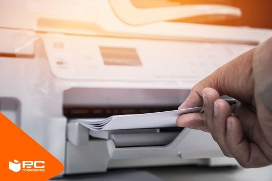 Un hombre saca folios de una impresora blanca