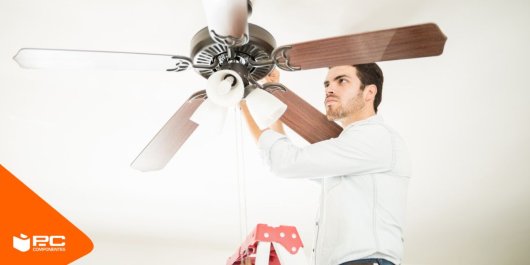 Una persona instala un ventilador de techo de 5 aspas
