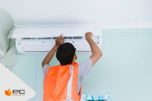 Un operario instala un aire acondicionado fijo