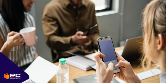 Une fille utilise un mobile dans une bibliothèque pour étudier