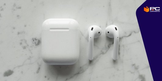 Unos Airpods de Apple blancos junto a su estuche