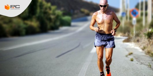 Un hombre practica runnning por una carretera con un reloj inteligente