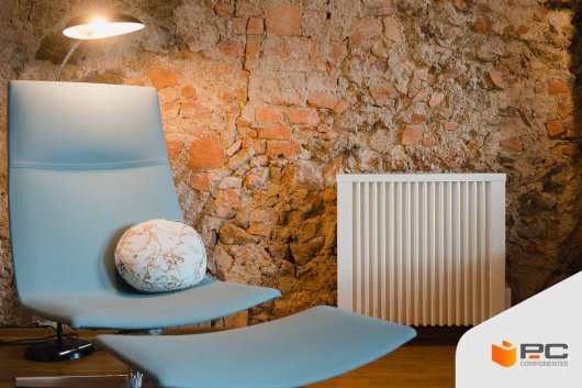 Un radiador en un salón junto a un sofá