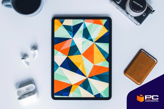 Um dos melhores tablets baratos e bons sobre uma mesa ao lado de uns auscultadores e uma carteira